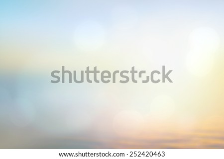 An abstract blurred ocean seascape. Sandy beach backdrop with turquoise water and bright sun light. Summer holidays concept.