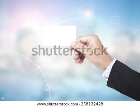 Asian business man hands holding a blank business card over blurred working people in office background.
