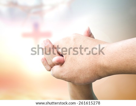 Clasping hand over blurred the cross on sunset background. Health Care, Fathers Day, Responsibility, Worship, Forgiveness, Repentance, Reconcile, Adoration, Glorify, Redeemer, Relationship concept.