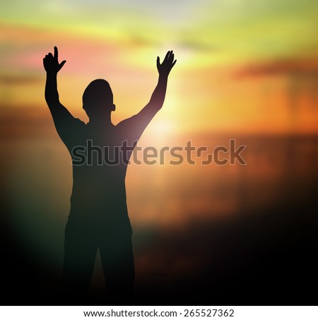 Silhouette human raising hands over blurred the white cross on nature background.