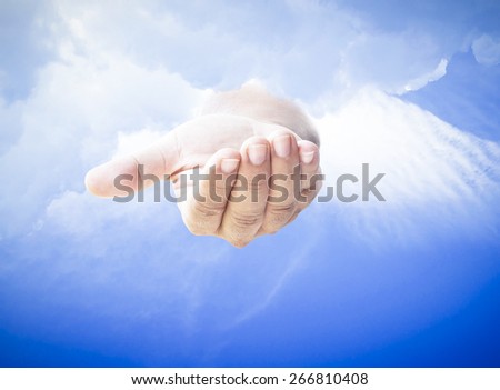 Human open empty hand with palms up over blue sky background.