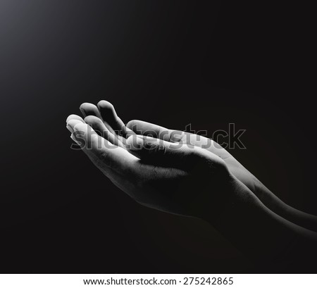 Black and white human open empty hands with palms up, over black background.