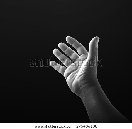 Black and white human open empty hand with palms up over black background.