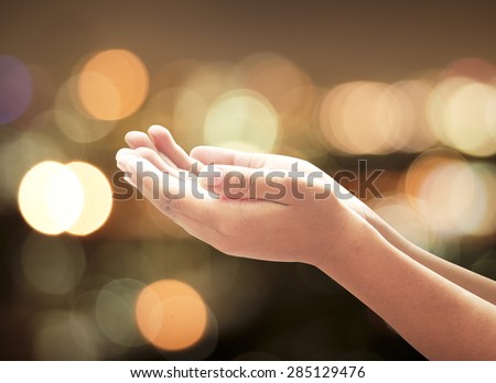 Human open empty hands with palms up over candle lights bokeh. Pray for support concept.