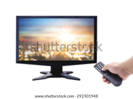 Human hand holding remote over blurred monitor display aerial view of Bangkok Skyline along Taksin bridge across Chao Phraya river. Isolated on white background.