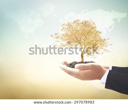 Businessman hands holding golden plant on blurred world map of clouds over beautiful nature background. Ecology, Environment, Business, Investment concept.