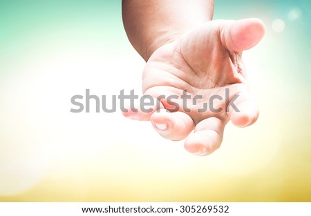 Human hand open empty hands with palms up over blurred nature, gesture of asking for the help or reach for helping someone who is troubled. Pray for support concept. Established principle concept.