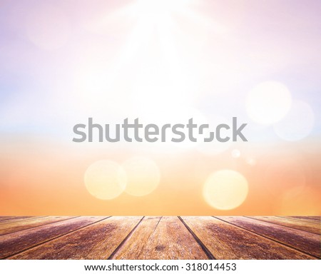 Wooden paving with abstract blurred textured background: yellow and green patterns. Blurred nature background. Sandy beach backdrop with turquoise water and bright sun light. Summer holidays concept.