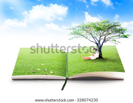 Open book of nature in a beautiful asian girl reading book under big tree on green meadow over blue sky background.