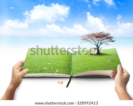 Human hands open turning next page of nature\'s book in a beautiful asian girl reading book under red big tree on green meadow over the beach and blue sky background. Open Book Of Nature concept.