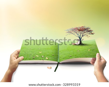 Open book in a beautiful asian girl reading book under red big tree on blurred autumn sunset background.