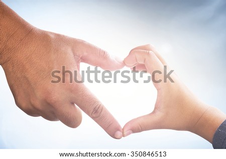Father and son hands up to blue sky in the shape of a heart around the sun. Creation, Love, Happy Valentine Day, God and Adam, Holy Bible, Health Care, World Cancer, Romantic, CSR, Kid, Child concept.