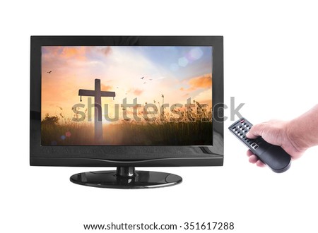 Represents the cross. Human hand holding remote and monitor display silhouette cross on blur beautiful autumn sunset with amazing light background isolated on white. Merry Christmas Card concept.