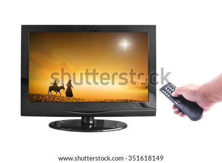 Represents nativity Story. Human hand holding remote and monitor display silhouette Mary Joseph journey through the desert with a donkey on golden sunset looking for a place to stay on Christmas Eve.