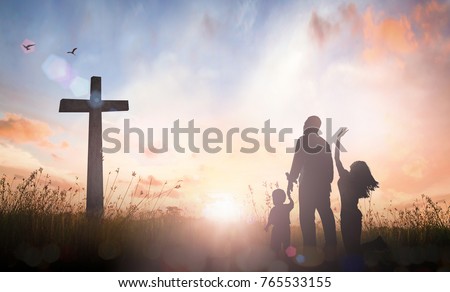 Faith concept: Silhouette Family worshipping God on autumn sunrise background.