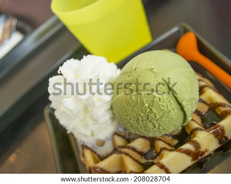 green tea ice cream on the table with waffle and whipped cream