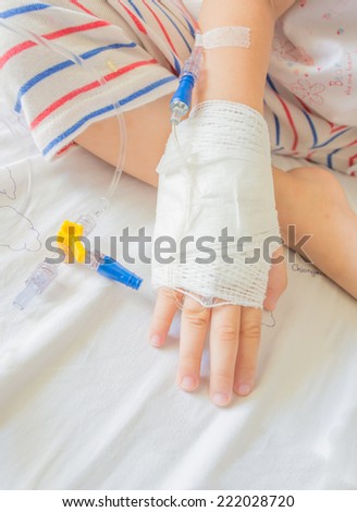 image of IV solution in a child\'s patients hand.