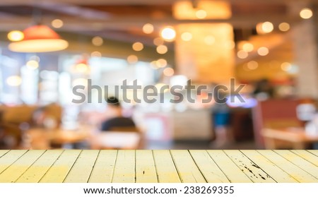 Empty wood table and blurred coffee shop  background .