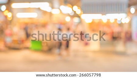 image of blurred background night market on street decorated with festive lights.