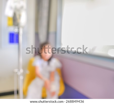 blurred image of Patient sit on the chair with drip in hospital for background usage.