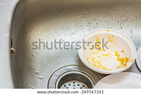 Kitchen conceptual image. Dirty sink with many dirty dishes and kitchenware.