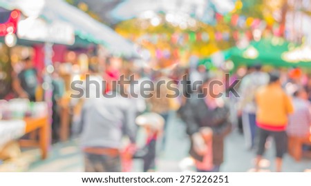 Blurred image of people walking at day market  in sunny day, blur background with bokeh