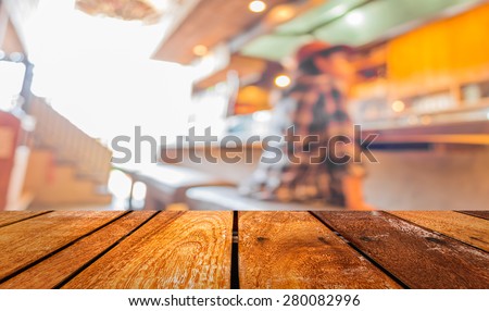 blur image of Young slim girl sits on a high bar stool in cafe .