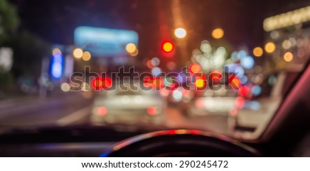 blur image of inside cars with bokeh lights from traffic jam on night time.