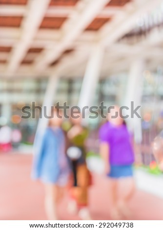 blur image of people walking at corridor with open space to the green garden for background usage.