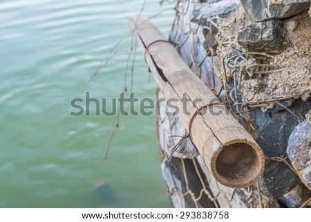 image of net made from wire covering the rocks near shore line.