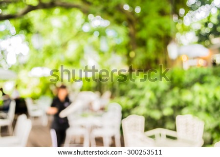 image of blur outdoor restaurant on day time with green tree bokeh for background usage .