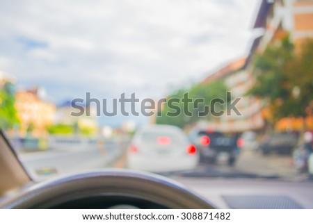 blur image of inside car in the city to see the road with bokeh lights for background usage.