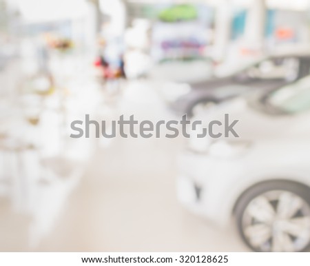 blur image of Commercially cars stand in show room of car shop.