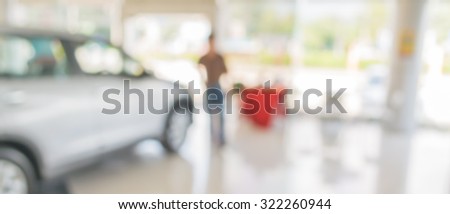 blur image of Commercially cars stand in show room of car shop for background usage.