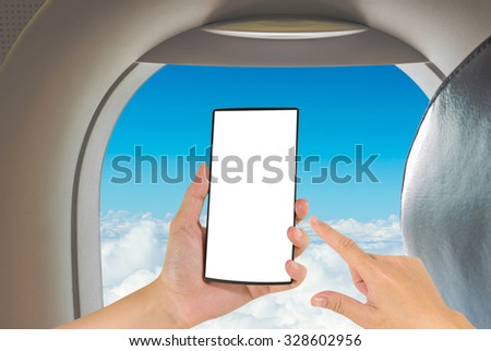 male hand is holding a modern touch screen phone and image of seat on airplane