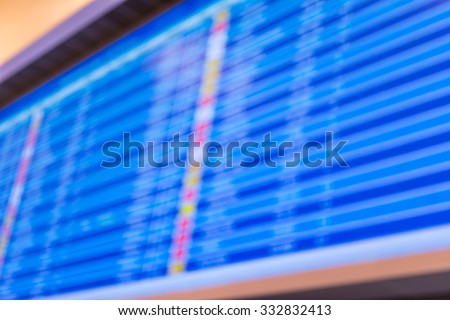 blur image of blue screen flight schedules in airport for background usage.
