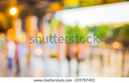 blurred  people walking at hallway decorated with festive lights for background usage .