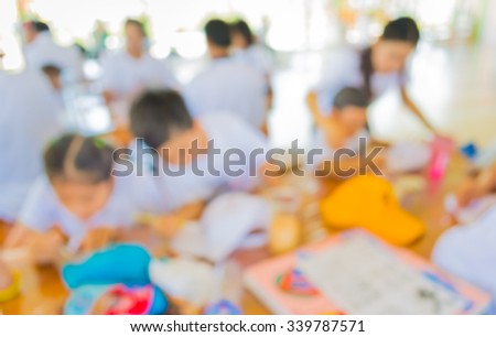 image of blur  kids drawing and painting on table in bright sunny playroom for background usage .