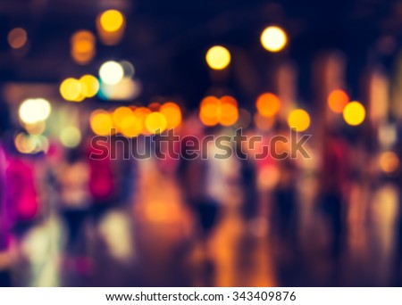 blurred  people walking at hallway decorated with festive lights for background usage .(vintage tone)
