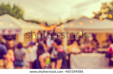 abstract blur image of food stall at day festival for background usage . (vintage tone)