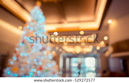 abstract blur image of shopping mall and decorated pine tree on christmas time for background . (vintage tone)