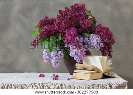 Lilac Bouquet in a clay vase and an opened book