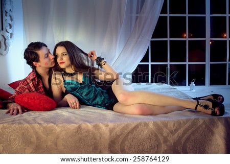 Young couple romancing in bed together. Passionate Couple in the bed