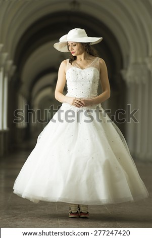 Young woman in white long dress and hat in sneakers. Long Shot. LS