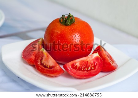 Tomato and slices of tomato on white background