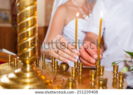Man and woman put a candle in church.
