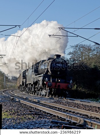 December 2014. Cathedrals Express Christmas market special passenger train with steam locomotives 44871 + 45407 at speed as they near the top of the climb at Elsenham Essex, UK.