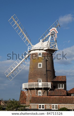 September 2011. The old Cley Windmill at Cley Next the Sea, Norfolk, England  . White sails against a blue sky with red brown brickwork. Now used as a hotel. Next the Sea,