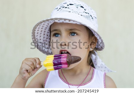 portrait of happy girl with blue eyes in a hat who is eating ice cream