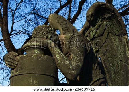 Angel statue with the funeral urn in cemetery